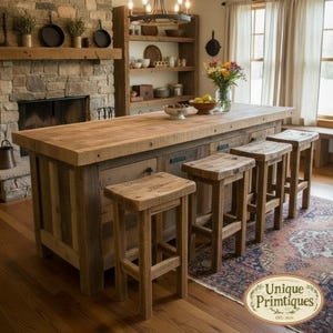 May include: A large rectangular kitchen island made of reclaimed wood with a thick countertop and four matching wooden bar stools. The island features dark metal hardware, drawers, and cabinets, positioned in a room with a stone fireplace and shelving.