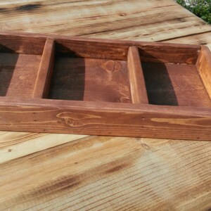 Puede incluir: Una bandeja de madera con tres compartimentos. La bandeja est&aacute; hecha de madera natural y tiene un acabado r&uacute;stico.