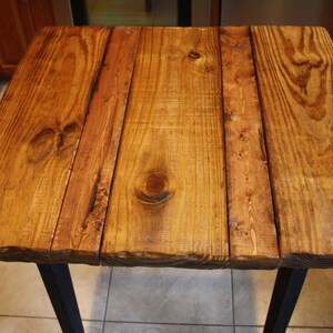 Puede incluir: Una tapa de mesa de madera r&uacute;stica con un acabado de madera natural. La tapa de mesa est&aacute; hecha de varias tablas de madera que se han unido. La madera tiene un color marr&oacute;n miel c&aacute;lido y una textura ligeramente rugosa.
