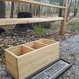 May include: A wooden box with three compartments, made by Unique Primitives Custom Woodworking. The box is sitting on a gravel path in front of a wooden fence.