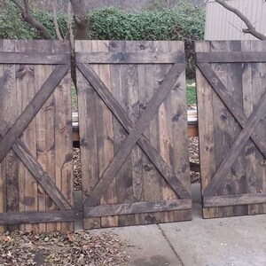May include: Three wooden doors with a dark brown stain and an 'X' design. The doors are made of reclaimed wood and have a rustic look.