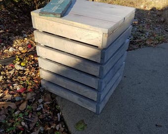 May include: A gray wooden crate with a sign that says "Welcome Home" on top. The crate is made of reclaimed wood and has a rustic look.