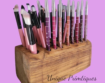 May include: Wooden makeup brush and lip liner holder with 18 slots. The holder is made of natural wood and has a rustic finish. The holder is filled with various makeup brushes and lip liners.