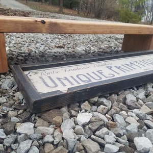 May include: A rustic wooden shelf with a black sign that reads "Rustic Farmhouse Furniture Unique Primitives".