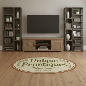 May include: An oval area rug featuring the text Unique Primtiques EST. 2010 in green lettering, surrounded by a decorative vine border. The rug is positioned in front of a wooden media console and two tall wooden shelving units filled with decor.