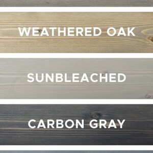May include: Five wood samples stained in different shades of gray. The stains are labeled "Classic Gray", "Weathered Oak", "Sunbleached", "Carbon Gray", and "Weathered Gray".