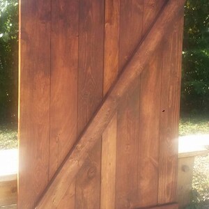 May include: A rustic wooden door with a diagonal brace and a sign that reads "Unique Primitives".