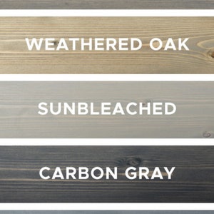 Puede incluir: Cinco muestras de madera te&ntilde;idas en diferentes tonos de gris. Las manchas est&aacute;n etiquetadas como "Gris Cl&aacute;sico", "Roble Desgastado", "Descolorido por el Sol", "Gris Carb&oacute;n" y "Gris Desgastado".
