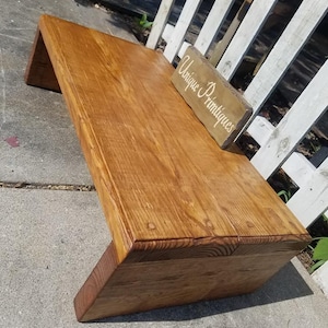 Puede incluir: Una mesa de caf&eacute; de madera r&uacute;stica con un acabado de madera natural. La mesa tiene un dise&ntilde;o sencillo con una tapa rectangular y dos patas a cada lado. La mesa est&aacute; sentada sobre una superficie de concreto. Un peque&ntilde;o letrero de madera con el texto "Unique Printiques" est&aacute; sentado en la mesa.