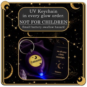 Puede incluir: Un llavero UV morado con un centro circular dorado que presenta el texto Lunaseas y una luna creciente. Junto a &eacute;l hay una tarjeta negra con el texto we all carry a little moonlight y un icono de luna creciente. El texto UV Keychain in every glow order. NOT FOR CHILDREN Small battery swallow hazard se muestra arriba.