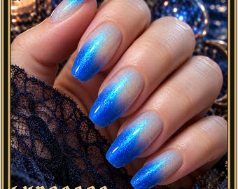 May include: Long fingernails featuring a vibrant blue to pale silver gradient polish with a fine glitter finish. The nails have a smooth, glossy texture and a rounded rectangular shape. The text LUNASEAS is printed in a gold font at the bottom.