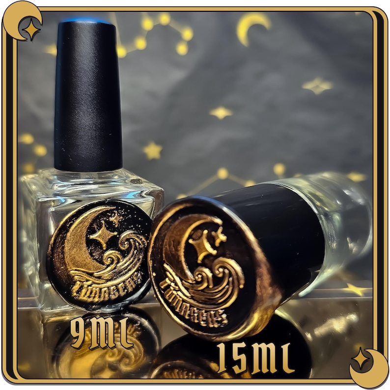 May include: Two glass bottles with black caps and gold labels. The labels feature a crescent moon, a star, and a wave design. The bottles are labeled "9 ml" and "15 ml".