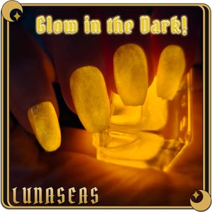 May include: Fingernails coated in a bright yellow glow-in-the-dark nail polish that emits a vibrant luminescence in low light. The text Glow in the Dark! appears at the top, and the brand name LUNASEAS is printed at the bottom.