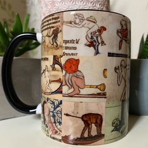 May include: A black coffee mug with a white design featuring a collage of medieval illustrations. The illustrations depict various figures and scenes, including a man playing a musical instrument, a woman riding a horse, and a man with a long beard.