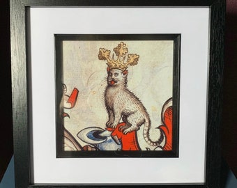 May include: A white cat wearing a gold crown with red and white accents. The cat is sitting on a red and white shield.