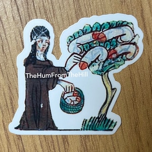 May include: A sticker featuring a medieval-style illustration of a person in a brown robe picking red fruit from a green tree. The person is holding a basket in their left hand. The text "TheHumFromTheHill" is printed on the sticker.