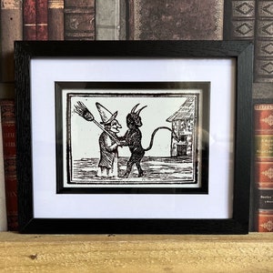 Devil hugging a witch Framed Print