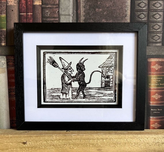 Devil hugging a witch Framed Print