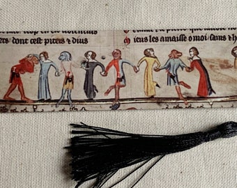 May include: A bookmark with a colorful illustration of people dancing, with text in French. The bookmark has a black tassel.