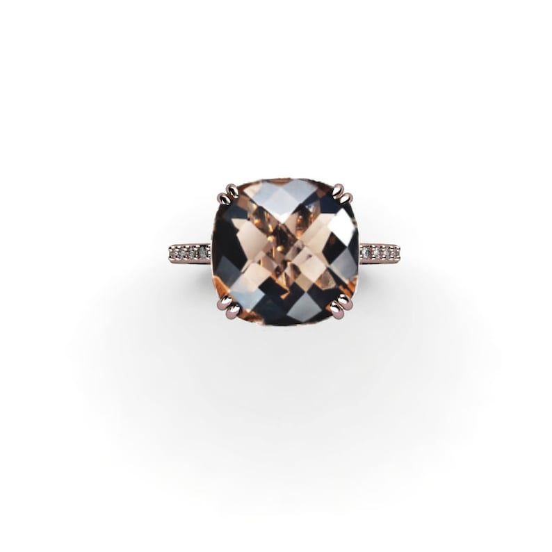 May include: A rose gold ring with a large, square-shaped, brown gemstone surrounded by smaller, clear gemstones.