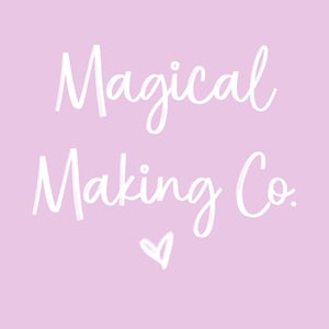 May include: A pale purple background with the words "Magical Making Co." in white script. A small white heart is below the text. The image is a logo for a creative business.