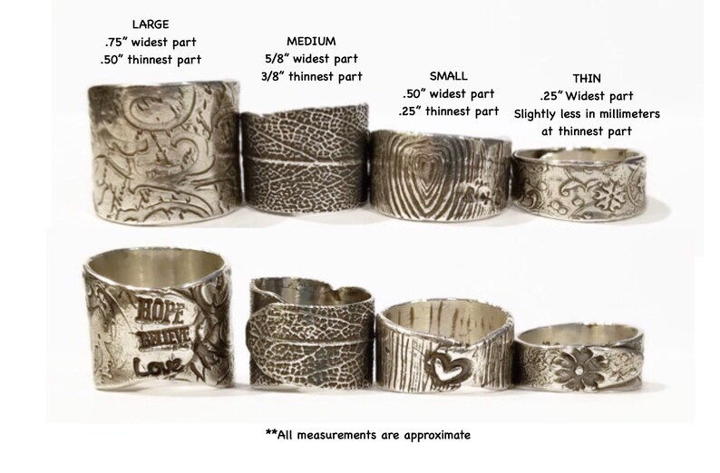 May include: A set of eight silver rings with different designs and widths. The rings are arranged in two rows, with the largest ring on the left and the smallest ring on the right. The rings are all made of silver and have a textured surface. The rings are all approximately 3/8 inch thick.