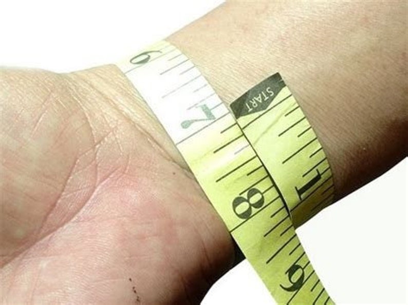 May include: A yellow measuring tape wrapped around a wrist, with the text "START" visible on the tape.