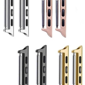 May include: Set of six watch band adapters in silver, rose gold, black, and gold. Each adapter has a silver metal bar and four black plastic tabs.