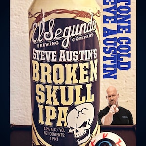 May include: A beer can for Steve Austin's Broken Skull IPA, with a skull graphic and the text "El Segundo Brewing Company." A small candle sits on top of the can. A Stone Cold Steve Austin image and an eyeball are also in the image.