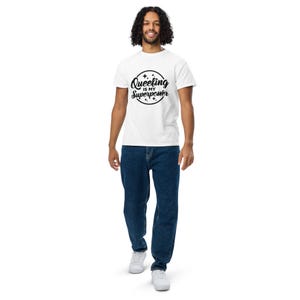 May include: White t-shirt with the text "Queeling is my Superpower" in a black circular design. The person is wearing blue jeans and white sneakers.
