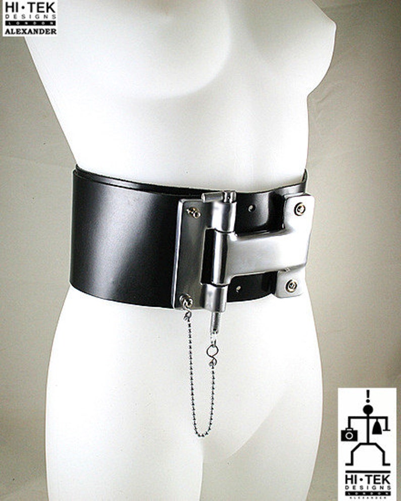 May include: A black leather belt with a silver metal hinge and a chain attached. The belt is worn on a white mannequin.