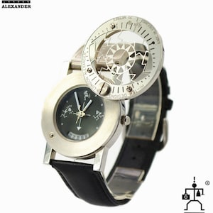 May include: A silver wristwatch with a black leather band. The watch face has a black background with white markings and a small window displaying the date. The watch has a unique design with a rotating outer ring that features a compass and a scale in meters.