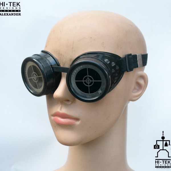 Może przedstawiać: Czarne gogle steampunk z okrągłymi szkłami z wzorem tarczy. Gogle mają regulowany czarny pasek i napis "LONDON" na prawym szkle.