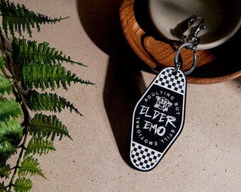 May include: Black and white keychain with a checkered pattern and the text "Adulting but still emotional, Elder Emo".