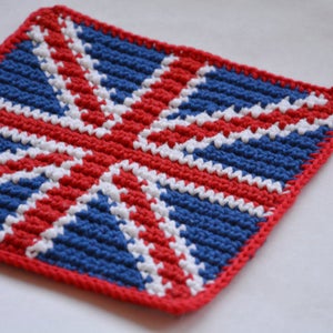Könnte beinhalten: Ein gehäkelter Topflappen in Form der Union Jack Flagge. Die Flagge ist aus rotem, weißem und blauem Garn gefertigt.