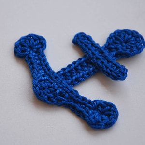Könnte beinhalten: Ein blauer gehäkelter Anker mit einem einfachen Design.