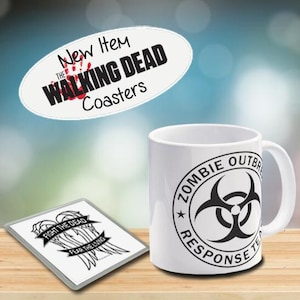 May include: A white ceramic mug featuring a black and white "Zombie Outbreak Response Team" design. A rectangular coaster with the text "Fight the Dead, Fear the Living" and a "The Walking Dead" coaster are also shown.