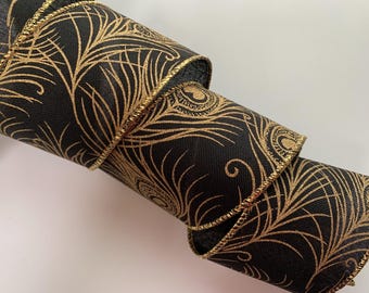 May include: Rolled black ribbon with a gold peacock feather design. The ribbon has a gold stitched edge. The design is a repeating pattern of stylized peacock feathers. The ribbon is likely used for crafts, gift wrapping, or decorative purposes.