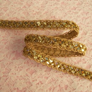 May include: Gold trim with iridescent sequins, woven into a braided design. This trim is perfect for adding a touch of sparkle to any project.