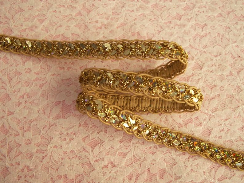 May include: Gold trim with iridescent sequins, woven into a braided design. This trim is perfect for adding a touch of sparkle to any project.