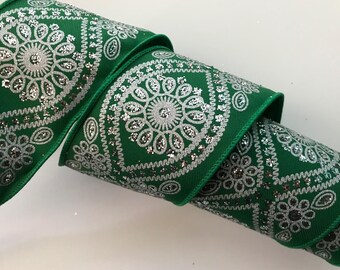 Puede incluir: Cinta verde y plateada con un patrón de paisley. La cinta tiene un acabado brillante.