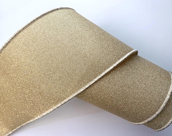 May include: A roll of gold glitter ribbon with a white edge and a dark brown trim. The ribbon is rolled up, showing the texture and sheen of the material. Ideal for crafts and gift wrapping.