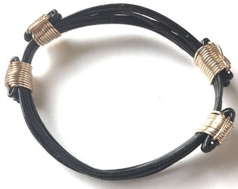 Pulsera de pelo sintético de elefante de 5 hebras con 4 nudos dorados.