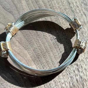 Silver bracelet / bangle with 4 sliding gold knots in elephant hair style