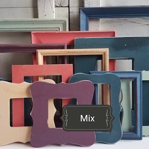 May include: A collection of colorful, empty picture frames in various sizes and shapes. The frames are painted in shades of blue, green, pink, purple, and beige. A dark gray label with the word "Mix" is in the center.