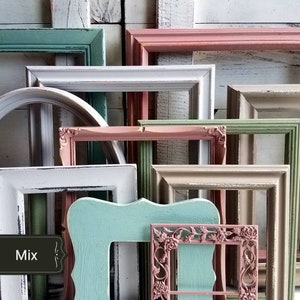 May include: A collection of various picture frames in different shapes and sizes. The frames are painted in a variety of colors, including white, pink, green, and blue. The word "Mix" is displayed on a small, dark-colored label.