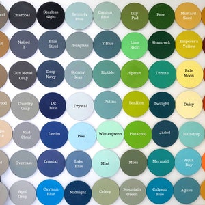 Peut inclure: Une collection d'&eacute;chantillons de peinture circulaires de diff&eacute;rentes couleurs, notamment des nuances de bleu, de vert, de marron et de rose. Chaque &eacute;chantillon est &eacute;tiquet&eacute; avec son nom de couleur, comme "Denim", "Shamrock" et "Pumpkin Pie". Les &eacute;chantillons sont dispos&eacute;s en grille.