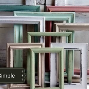 May include: A collection of various sized, rectangular picture frames in a variety of pastel colors, including teal, pink, white, and green. The frames have a distressed, vintage look, with visible wood grain and chipped paint. The word "Simple" is on a black label.