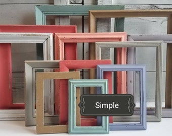 May include: A collection of rectangular picture frames in various colors, including white, pink, blue, and tan. The frames are arranged in a layered composition, with a distressed, rustic finish. A black label with the word "Simple" is in the image.