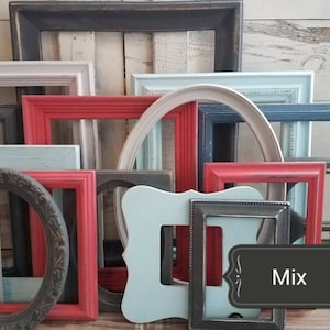 May include: A collection of various picture frames in different shapes and colors, including red, blue, white, and black. Some frames are oval, while others are rectangular or have unique shapes. The word "Mix" is displayed on a black label.